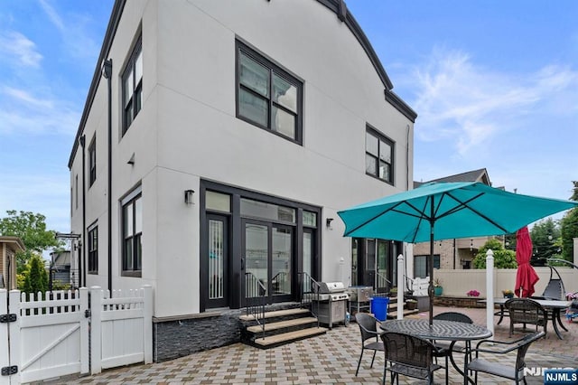 52 Myrtle Ave Unit B, Edgewater, NJ 07020 - back of property featuring a patio, a gate, stucco siding, and entry steps