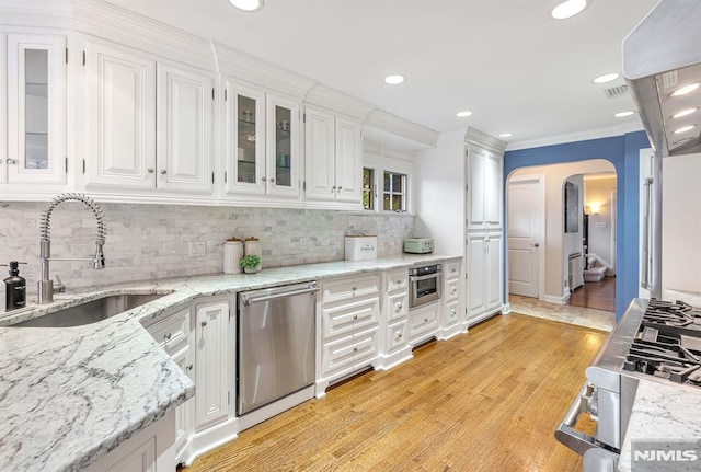 173 Sheridan Ave, Ho-Ho-Kus, NJ 07423 - kitchen featuring a sink, stainless steel dishwasher, white cabinets, arched walkways, and backsplash