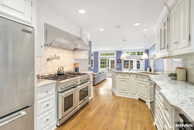 173 Sheridan Ave, Ho-Ho-Kus, NJ 07423 - kitchen featuring appliances with stainless steel finishes, wall chimney range hood, a sink, backsplash, and recessed lighting