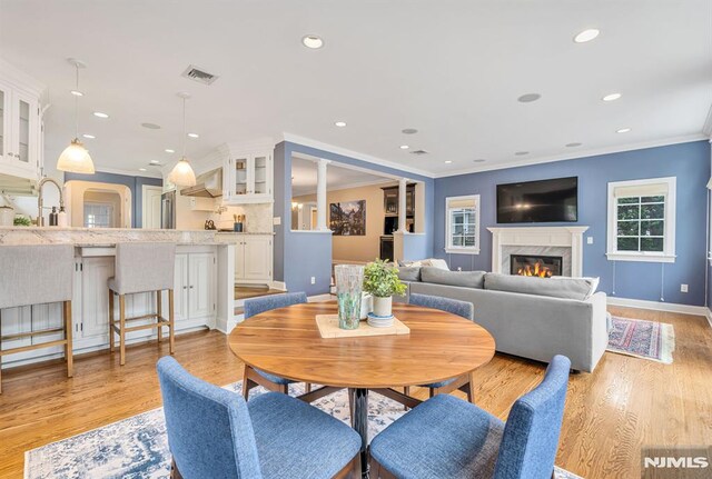 173 Sheridan Ave, Ho-Ho-Kus, NJ 07423 - dining space featuring ornamental molding, a fireplace, light wood-type flooring, baseboards, and recessed lighting