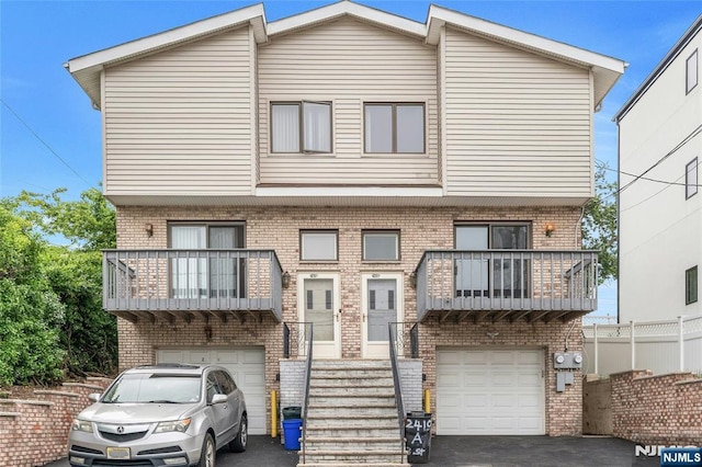 2410 3rd St, Fort Lee, NJ 07024 - townhome / multi-family property featuring a balcony, brick siding, and an attached garage
