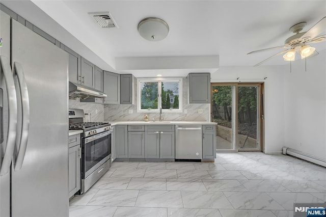 2410 3rd St, Fort Lee, NJ 07024 - kitchen with appliances with stainless steel finishes, gray cabinets, under cabinet range hood, and light marble finish flooring