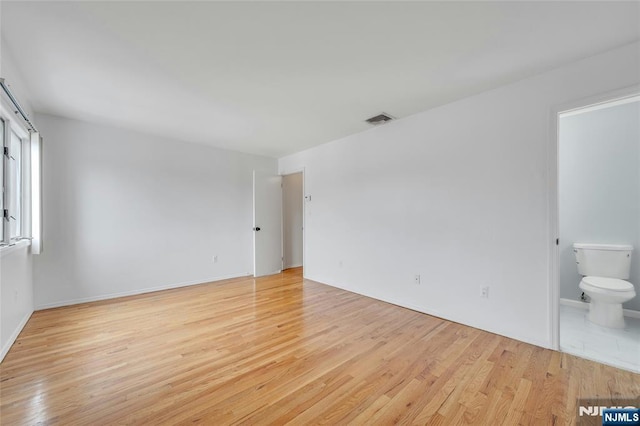 2410 3rd St, Fort Lee, NJ 07024 - unfurnished bedroom with light wood finished floors, ensuite bathroom, and baseboards