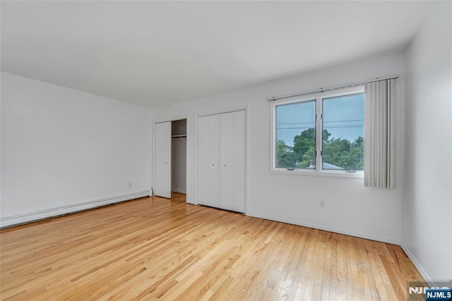 2410 3rd St, Fort Lee, NJ 07024 - unfurnished bedroom with wood finished floors, multiple closets, a baseboard heating unit, and baseboards