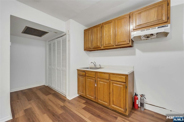 2410 3rd St, Fort Lee, NJ 07024 - kitchen with a sink, under cabinet range hood, dark wood-type flooring, and light countertops