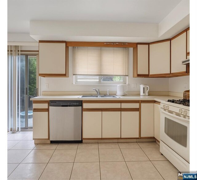 2410 3rd St, Fort Lee, NJ 07024 - kitchen with dishwasher, white range with gas cooktop, a sink, cream cabinets, and light countertops