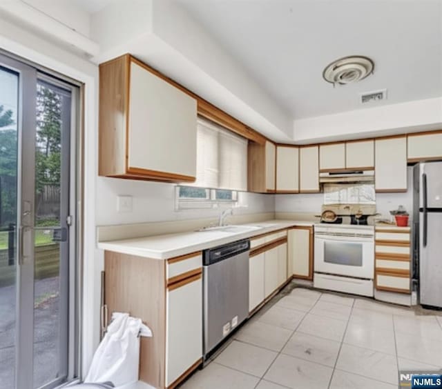 2410 3rd St, Fort Lee, NJ 07024 - kitchen featuring appliances with stainless steel finishes, light countertops, under cabinet range hood, and healthy amount of natural light