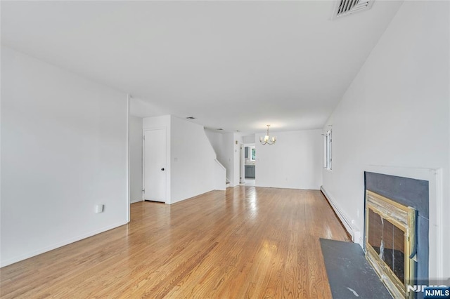 2410 3rd St, Fort Lee, NJ 07024 - unfurnished living room with baseboard heating, a chandelier, stairway, light wood-style flooring, and a fireplace with flush hearth