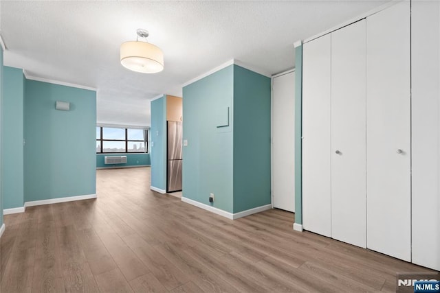 7004 E Kennedy Blvd Unit 28C, Guttenberg, NJ 07093 - unfurnished bedroom featuring wood finished floors, baseboards, freestanding refrigerator, a closet, and a textured ceiling