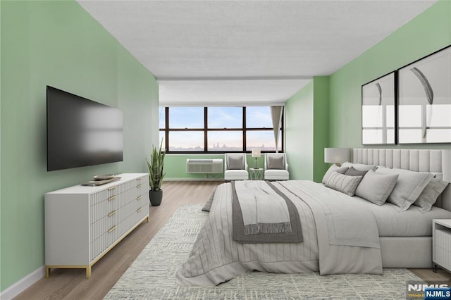 7004 E Kennedy Blvd Unit 28C, Guttenberg, NJ 07093 - bedroom featuring baseboards, light wood finished floors, and a wall mounted AC