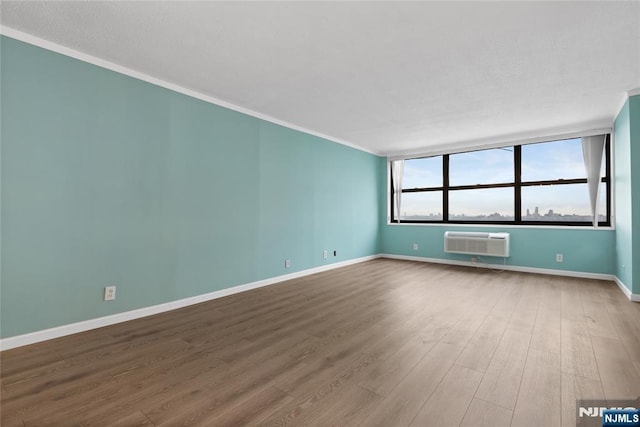 7004 E Kennedy Blvd Unit 28C, Guttenberg, NJ 07093 - spare room featuring an AC wall unit, wood finished floors, ornamental molding, and baseboards