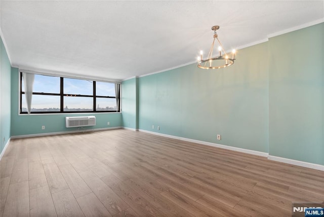 7004 E Kennedy Blvd Unit 28C, Guttenberg, NJ 07093 - spare room with a wall mounted air conditioner, wood finished floors, a chandelier, baseboards, and crown molding