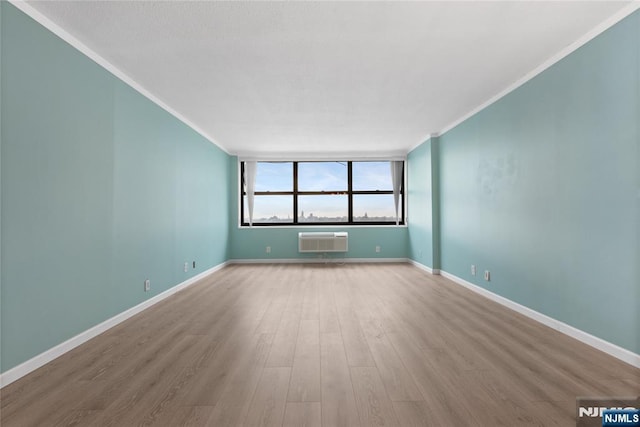 7004 E Kennedy Blvd Unit 28C, Guttenberg, NJ 07093 - empty room with ornamental molding, an AC wall unit, wood finished floors, and baseboards