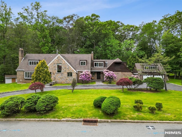 45 Longridge Rd, Montvale, NJ 07645 - view of front of property with a chimney, stone siding, and a front lawn