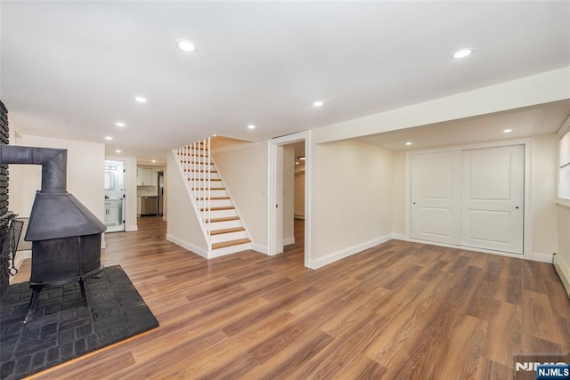 112 Fern St, Twp Of Washington, NJ 07676 - finished basement with stairway, wood finished floors, a wood stove, baseboards, and recessed lighting