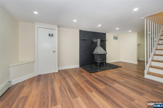 112 Fern St, Twp Of Washington, NJ 07676 - unfurnished living room featuring a baseboard heating unit, stairs, wood finished floors, a wood stove, and recessed lighting