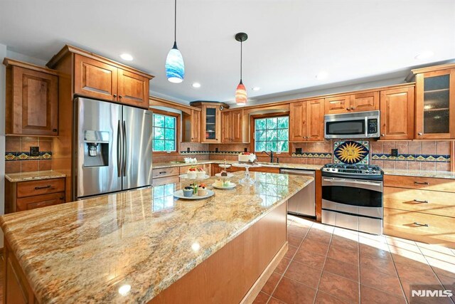 68 Birch St, Ramsey, NJ 07446 - kitchen featuring appliances with stainless steel finishes, a sink, brown cabinets, backsplash, and light stone counters