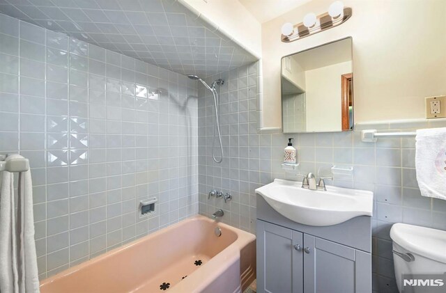 68 Birch St, Ramsey, NJ 07446 - bathroom featuring tub / shower combination, vanity, toilet, and tile walls