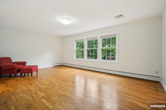 71 Louville Ave, Park Ridge, NJ 07656 - living area featuring a baseboard heating unit, wood finished floors, and baseboards