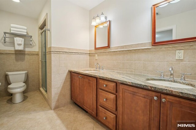 71 Louville Ave, Park Ridge, NJ 07656 - bathroom with tile walls, tile patterned floors, toilet, a stall shower, and wainscoting