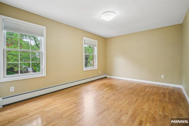71 Louville Ave, Park Ridge, NJ 07656 - empty room with baseboard heating, wood finished floors, plenty of natural light, and baseboards