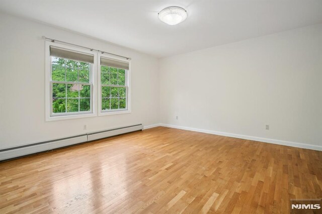 71 Louville Ave, Park Ridge, NJ 07656 - empty room with a baseboard radiator, light wood finished floors, and baseboards