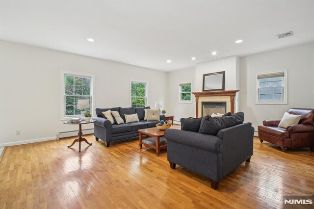 71 Louville Ave, Park Ridge, NJ 07656 - living room featuring a baseboard radiator, light wood finished floors, recessed lighting, a glass covered fireplace, and baseboards