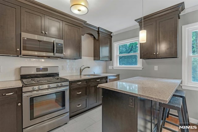 151 Palisade Ave Unit C8, Englewood, NJ 07631 - kitchen with stainless steel appliances, a sink, dark brown cabinetry, and ornamental molding