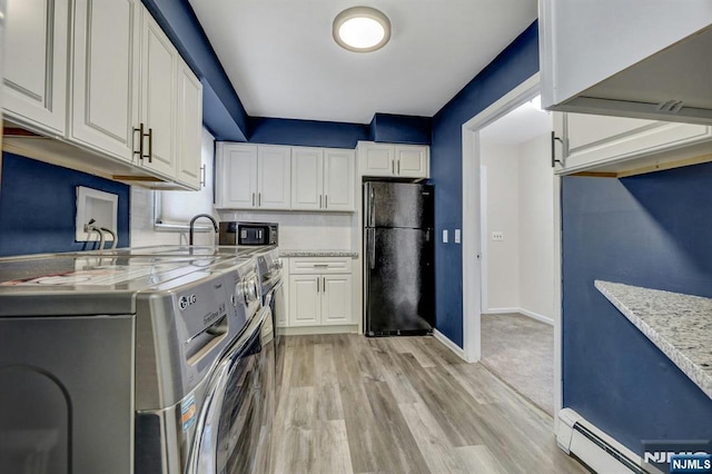 830 Pennsylvania Ave, Lyndhurst, NJ 07071 - kitchen with black appliances, washer / clothes dryer, a baseboard heating unit, white cabinetry, and light wood-type flooring