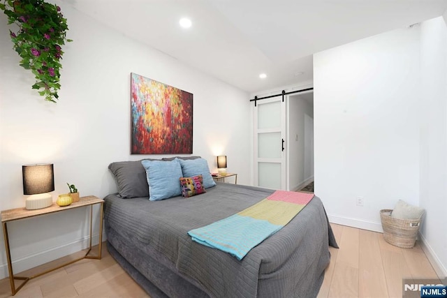 606 1st St Unit 1, Hoboken, NJ 07030 - bedroom with recessed lighting, a barn door, baseboards, and wood finished floors