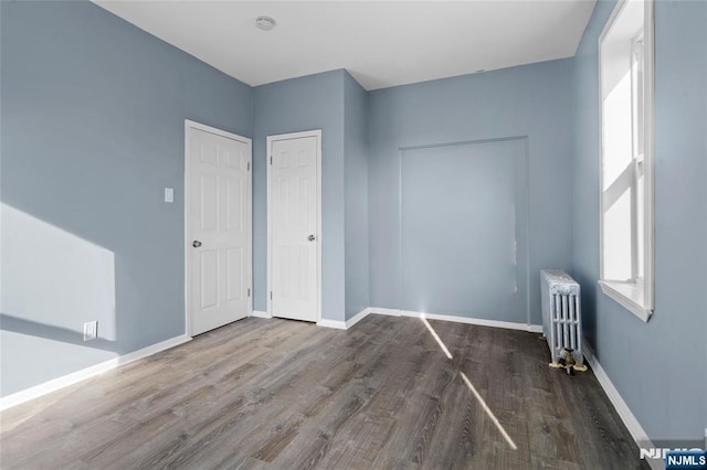 143 Duncan Ave Unit 8/108, Jersey City, NJ 07306 - unfurnished bedroom with radiator heating unit, wood finished floors, and baseboards