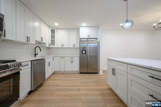 3 Bradshaw Ct Unit 509, Hillsdale, NJ 07642 - kitchen featuring stainless steel appliances, a sink, a chandelier, white cabinets, and glass insert cabinets