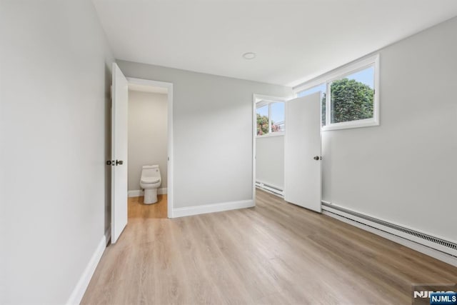 444 Black Oak Ridge Rd, Wayne, NJ 07470 - unfurnished bedroom with baseboard heating, a baseboard radiator, light wood-style flooring, and baseboards