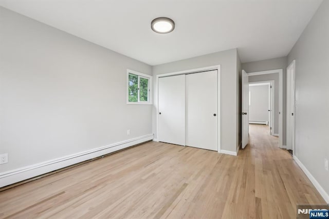 444 Black Oak Ridge Rd, Wayne, NJ 07470 - unfurnished bedroom with light wood-style floors, a baseboard heating unit, a closet, and baseboards