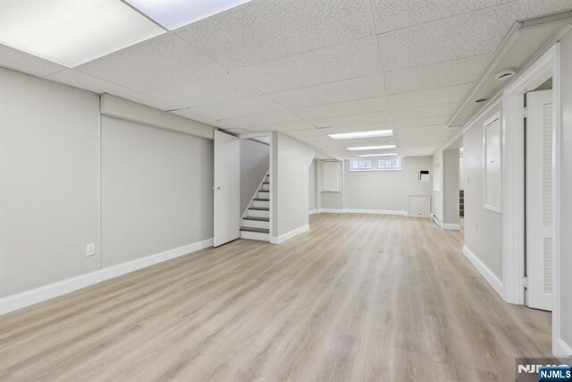 444 Black Oak Ridge Rd, Wayne, NJ 07470 - basement featuring stairs, light wood-style flooring, a paneled ceiling, and baseboards