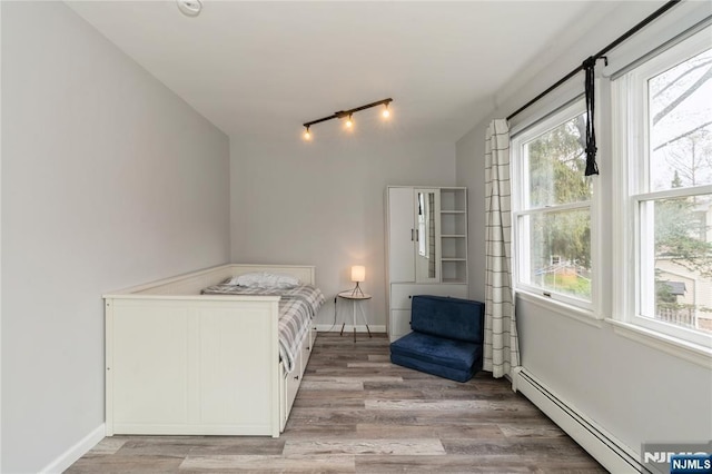 62 Valley Rd, Glen Rock, NJ 07452 - bedroom featuring baseboard heating, light wood-style flooring, track lighting, and baseboards