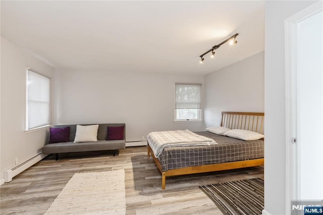 62 Valley Rd, Glen Rock, NJ 07452 - bedroom featuring a baseboard radiator, wood finished floors, and rail lighting