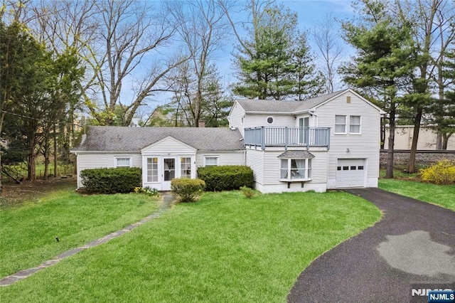 62 Valley Rd, Glen Rock, NJ 07452 - view of front of home with an attached garage, asphalt driveway, a balcony, a front yard, and a shingled roof