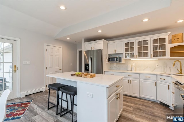 62 Valley Rd, Glen Rock, NJ 07452 - kitchen with stainless steel appliances, a sink, baseboard heating, a breakfast bar, and a kitchen island