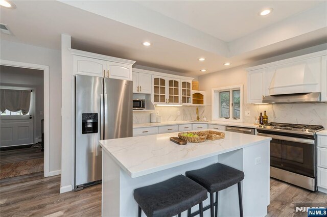 62 Valley Rd, Glen Rock, NJ 07452 - kitchen featuring appliances with stainless steel finishes, wood finished floors, white cabinetry, recessed lighting, and a center island