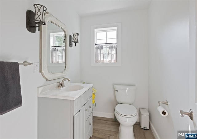 322 E Midland Ave, Paramus, NJ 07652 - bathroom featuring toilet, vanity, wood finished floors, and baseboards