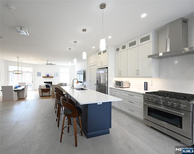 11 St Charles Ave, West Milford, NJ 07421 - kitchen featuring wall chimney range hood, stainless steel appliances, a sink, open floor plan, and a center island with sink