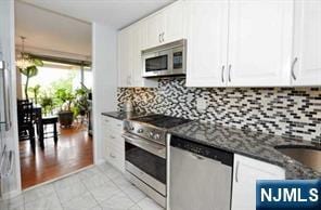 4 Horizon Rd Unit 404, Fort Lee, NJ 07024 - kitchen with stainless steel appliances, white cabinets, and backsplash