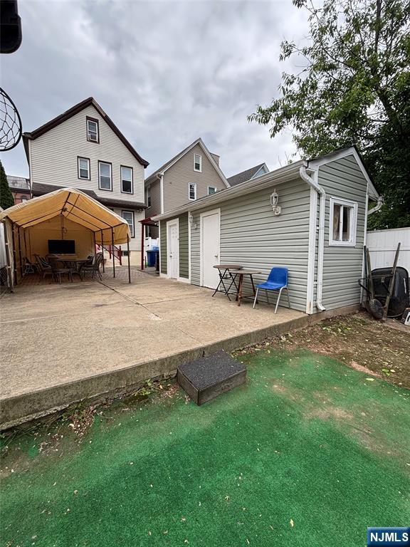 65 Dey St, Paterson, NJ 07503 - back of property featuring an outdoor structure and a patio