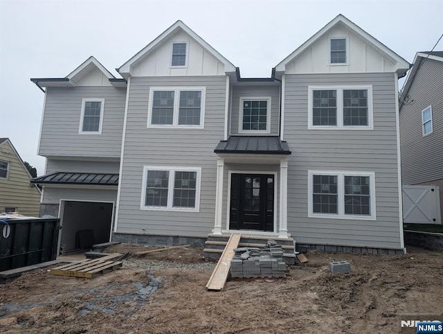265 Adams Ave, River Edge, NJ 07661 - view of front of house featuring a standing seam roof, metal roof, board and batten siding, and a garage