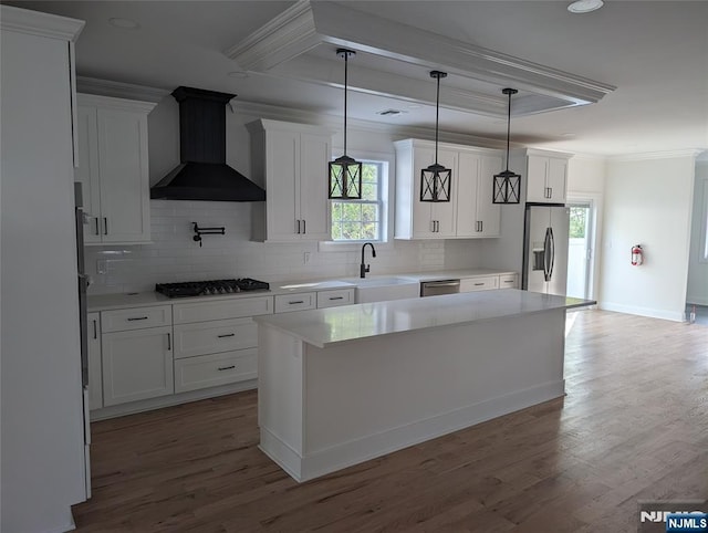 265 Adams Ave, River Edge, NJ 07661 - kitchen with wall chimney range hood, a sink, stainless steel appliances, crown molding, and plenty of natural light