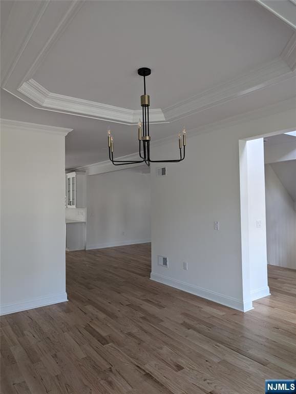 265 Adams Ave, River Edge, NJ 07661 - unfurnished dining area with a chandelier, crown molding, a raised ceiling, and wood finished floors