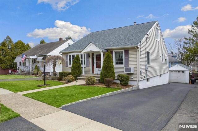 101 Pasadena Pl, Hawthorne, NJ 07506 - view of front of property featuring an outbuilding, roof with shingles, a front yard, a detached garage, and driveway