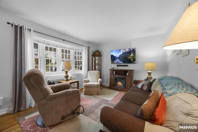 101 Pasadena Pl, Hawthorne, NJ 07506 - living room with wood finished floors, a warm lit fireplace, and baseboards