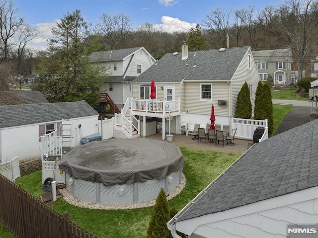 101 Pasadena Pl, Hawthorne, NJ 07506 - rear view of house featuring stairs, a wooden deck, a chimney, a covered pool, and a residential view